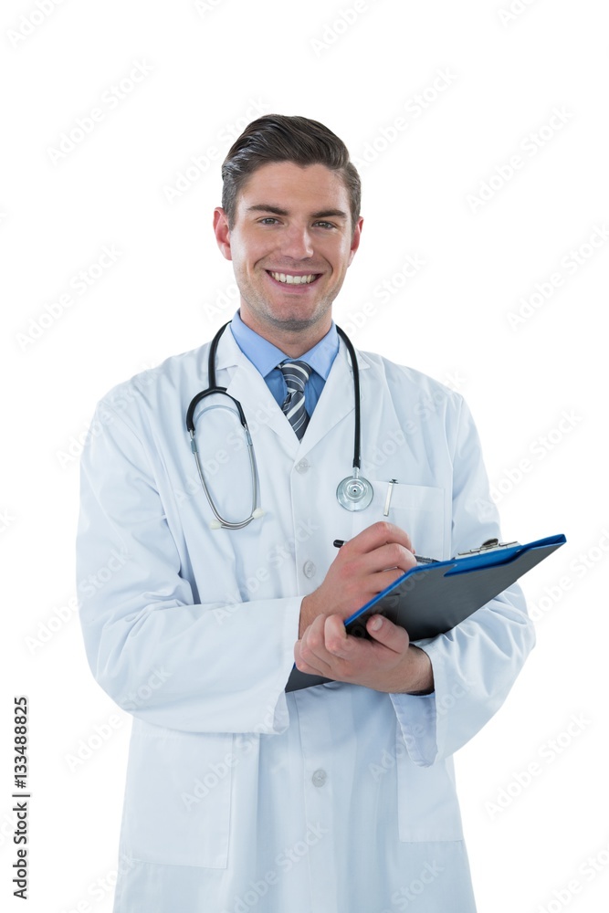 Smiling doctor writing with pen on clipboard Smiling doctor writing with pen on clipboard
