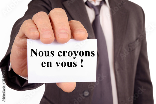 Homme tenant une carte avec écrit dessus nous croyons en vous