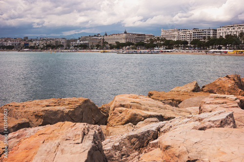 Buildings near seashore. Rocks, water and sky. Spend whole summer at resort.
