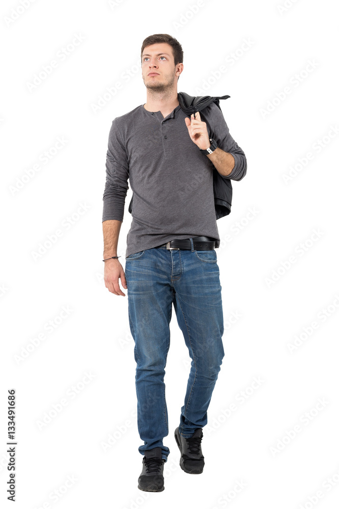 Front view of handsome casual man walking and carrying jacket over shoulder looking up. Full body length portrait isolated over white background. Front view of handsome casual man walking and carrying jacket over shoulder looking up. Full body length portrait isolated over white background.