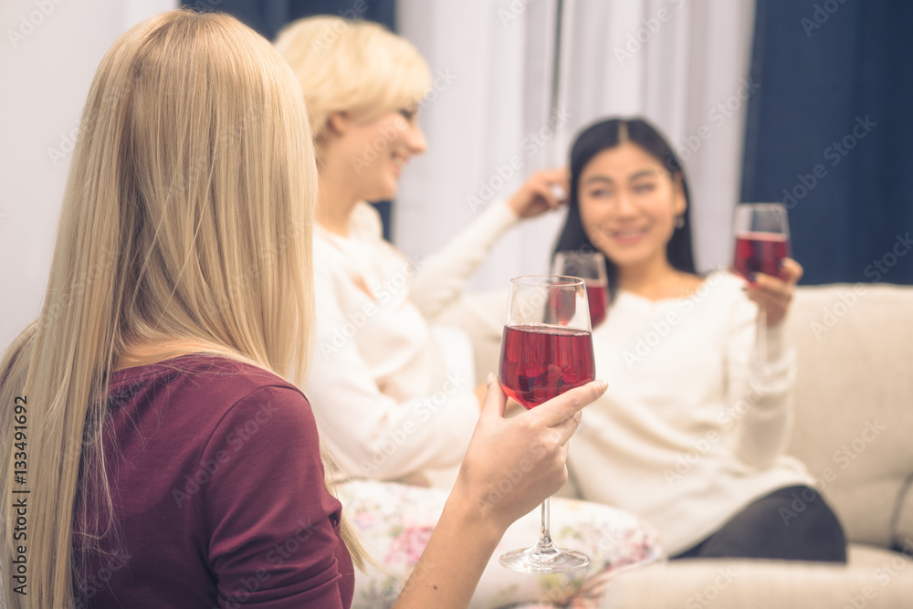 Home party concept. Closeup toned picture of friends girls having party at home. Pretty ladies drinking red wine from glasses and communicating. Home party concept. Closeup toned picture of friends girls having party at home. Pretty ladies drinking red wine from glasses and communicating.