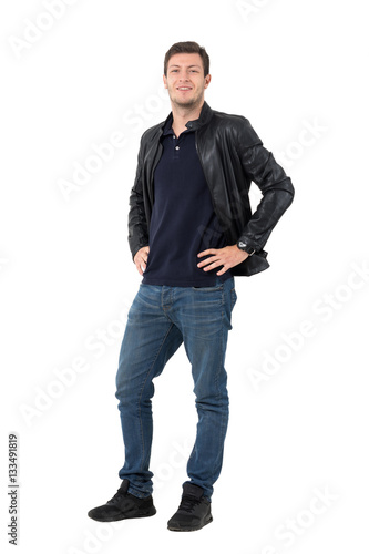 Obraz na plátně Young casual man with hands on hips smirking and looking at camera