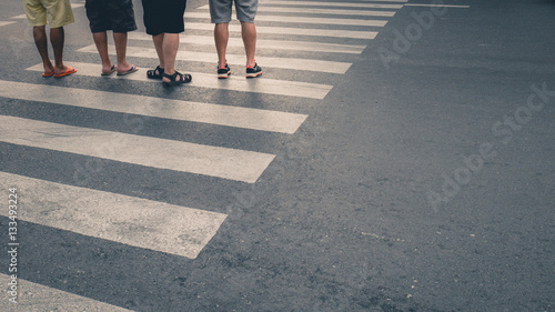 Motion of pedestrian zebra crossing or crosswalk in asia. Feet of the pedestrians crossing on city street closeup.