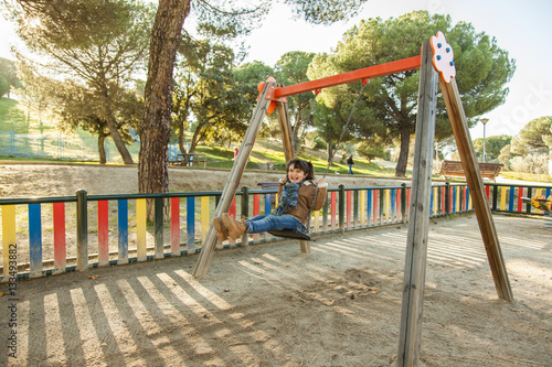 Wallpaper Mural Girl smiling having fun on swing at the playground Torontodigital.ca