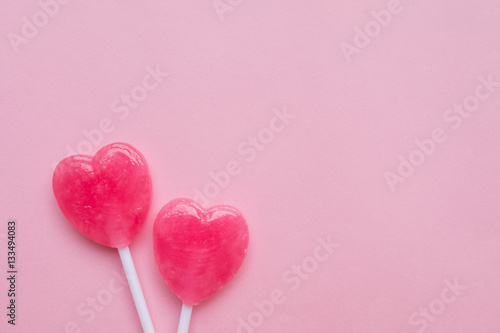 two Pink Valentine's day heart shape lollipop candy on empty pastel pink paper background. Love Concept. Knolling top view. Minimalism colorful hipster style.