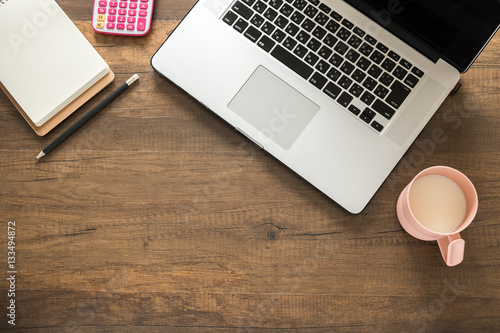 Working desk, Office and home office concept. with Laptop, Pencil, Memo, Calculator and Milk cup on wooden table. photo