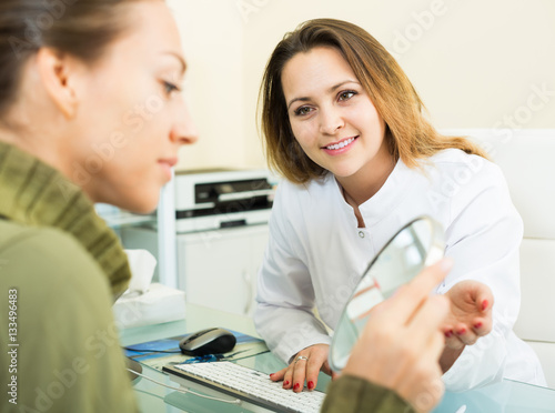 Woman client checking result of beauty procedures