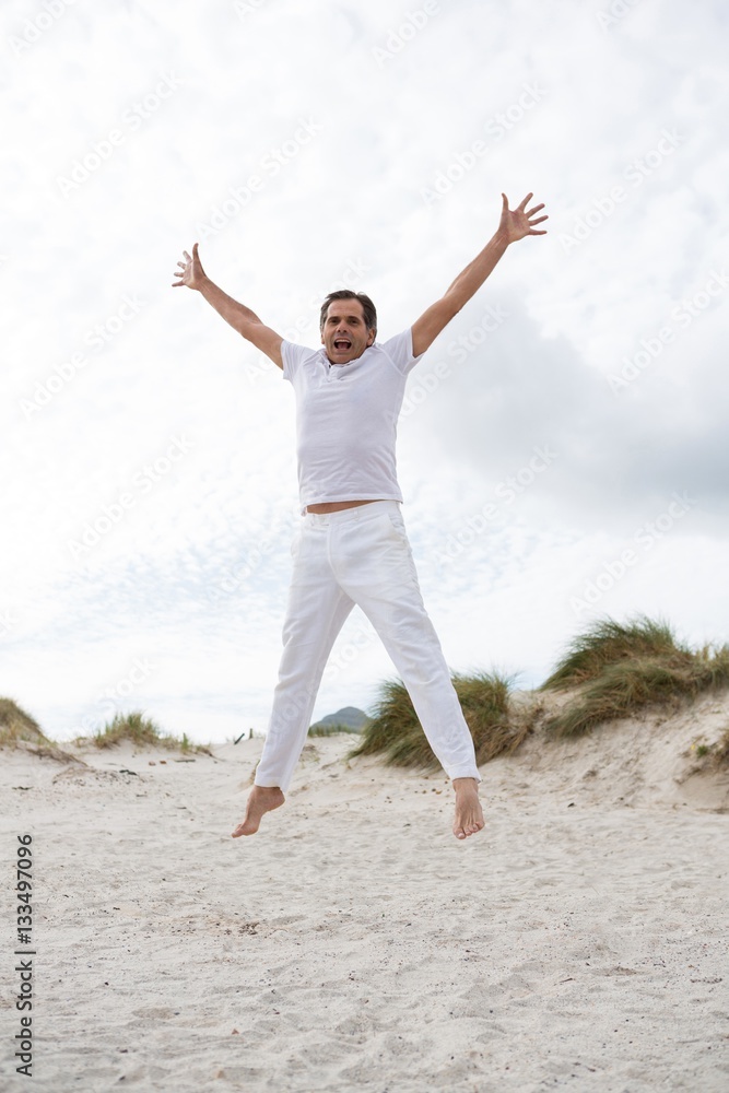 Excited man jumping on beach Excited man jumping on beach