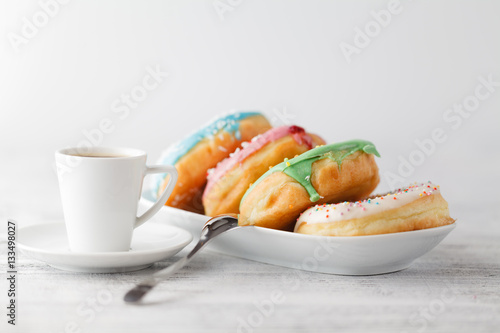 Fresh donuts on tray тв cup of hot espresso