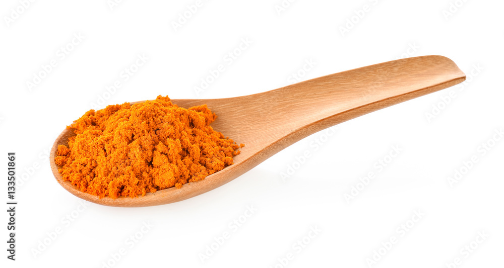 Turmeric powder in a wooden spoon on a white background Turmeric powder in a wooden spoon on a white background