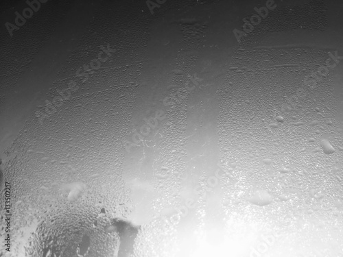 Blurry water drops on sunshine ffrozen window glass background photo