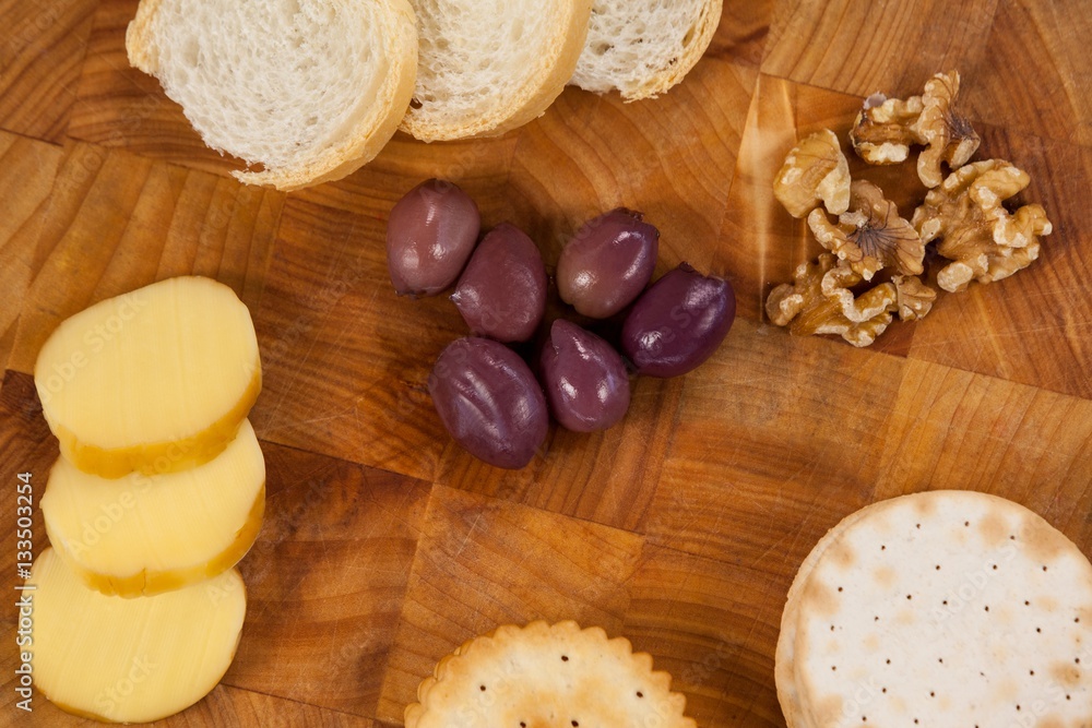 Cheese, bread, olives, biscuits and walnut on wooden board Cheese, bread, olives, biscuits and walnut on wooden board