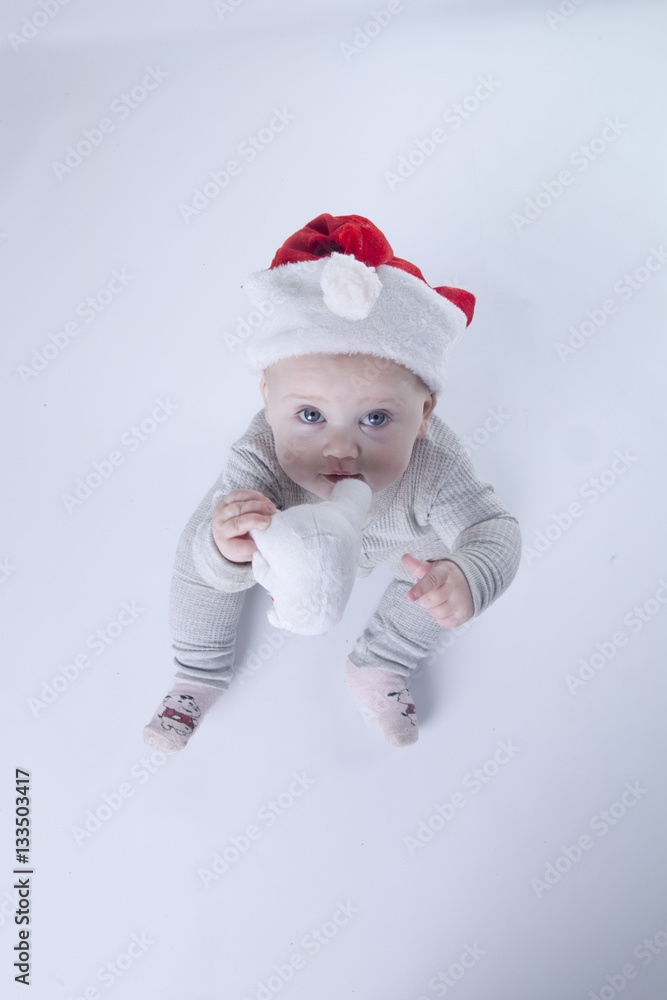 the kid on the background with blue eyes in a Christmas hat the kid on the background with blue eyes in a Christmas hat