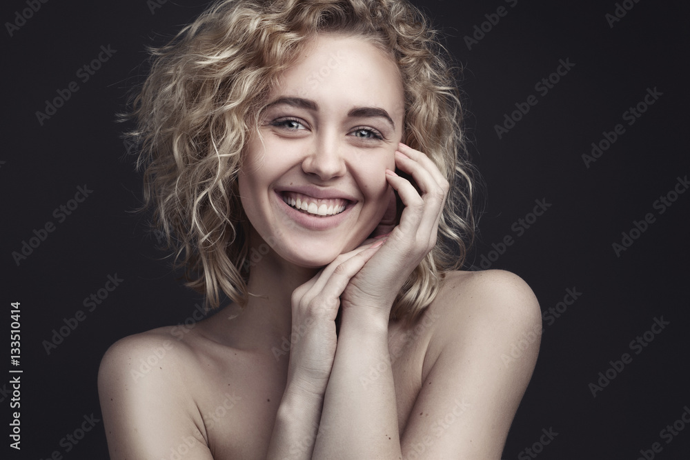 closeup Portrait of young smiling beautiful woman with light makeup over dark grey studio background closeup Portrait of young smiling beautiful woman with light makeup over dark grey studio background