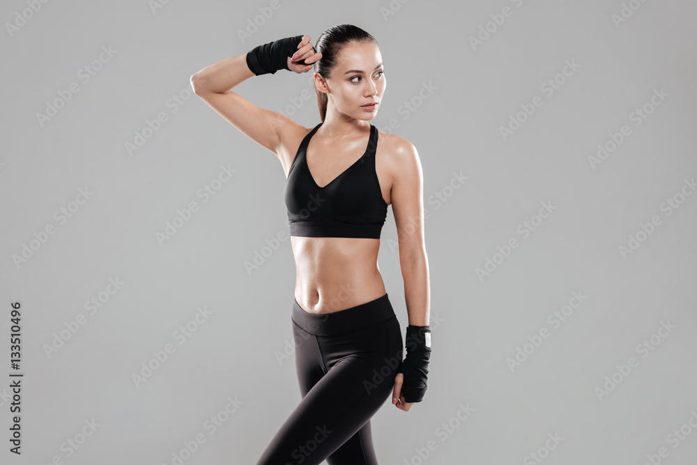 Pretty young fitness lady posing over grey background Pretty young fitness lady posing over grey background