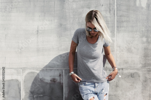 Hipster girl in gray t-shirt over street wall