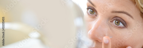 Woman putting eye lenses on