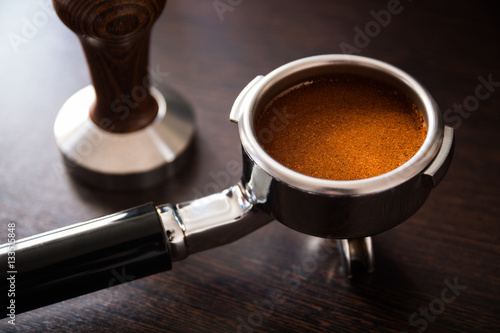 Slika na platnu Filter holder of professional coffee machine with tamped coffee and tamper