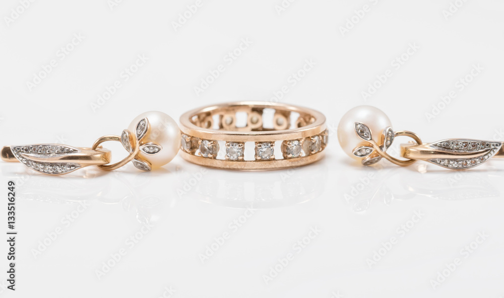Elegant gold earrings with pearls and a chunky ring with small d Elegant gold earrings with pearls and a chunky ring with small d