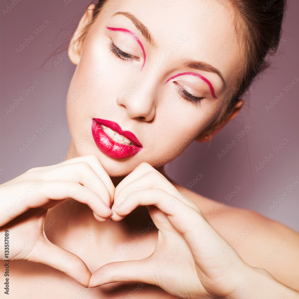 Fototapeta premium Beautiful brunette woman with red full lips and red lines on her eyelids and braid hairstyle