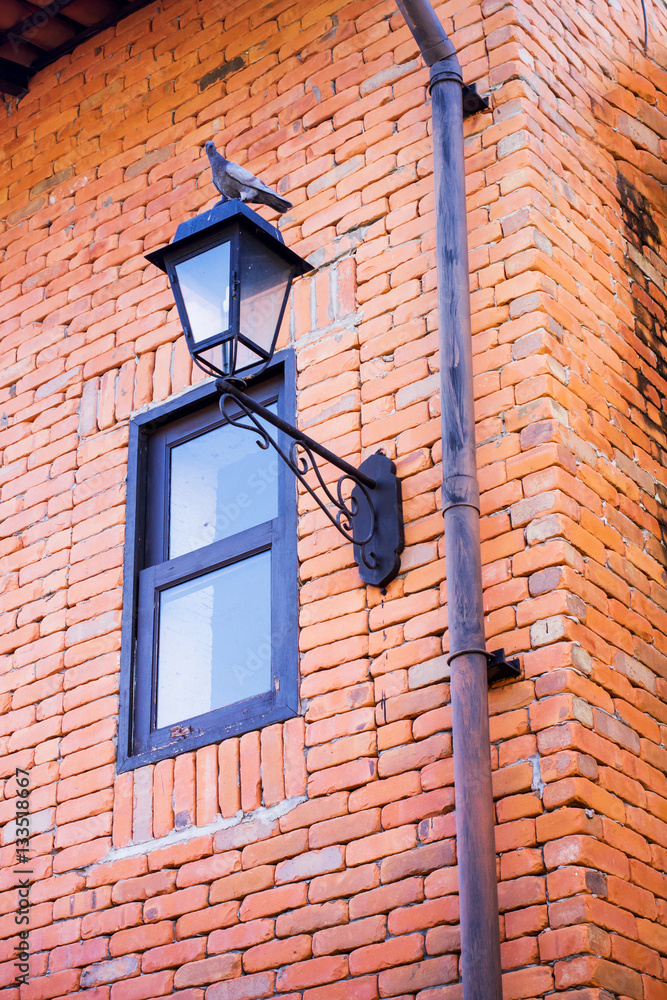 Classic iron hanging lamp on the brick wall Classic iron hanging lamp on the brick wall