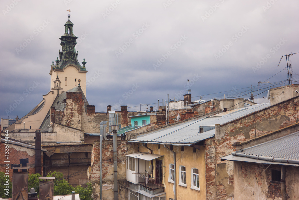 Rooftops and church tower. Brick buildings and sky. Religious landmark in old district.