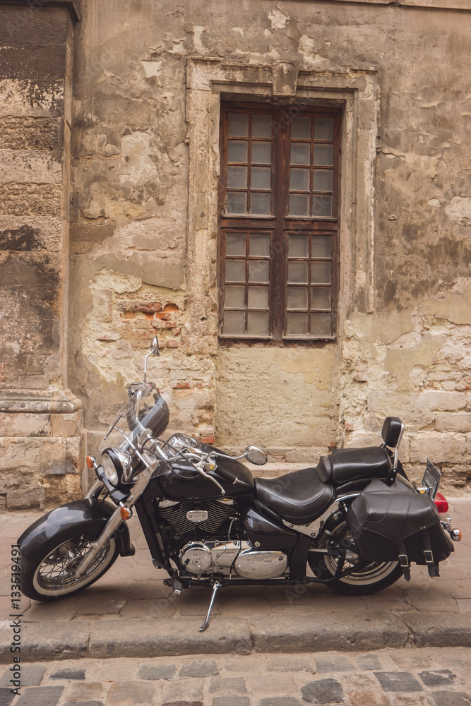 Black retro motorcycle. Motorbike near old wall. Respect the classics.