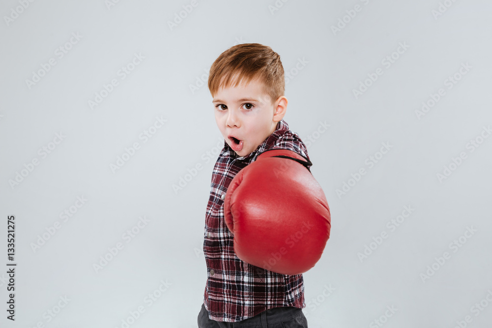 Litle boy in boxing gloves standing and fighting Litle boy in boxing gloves standing and fighting
