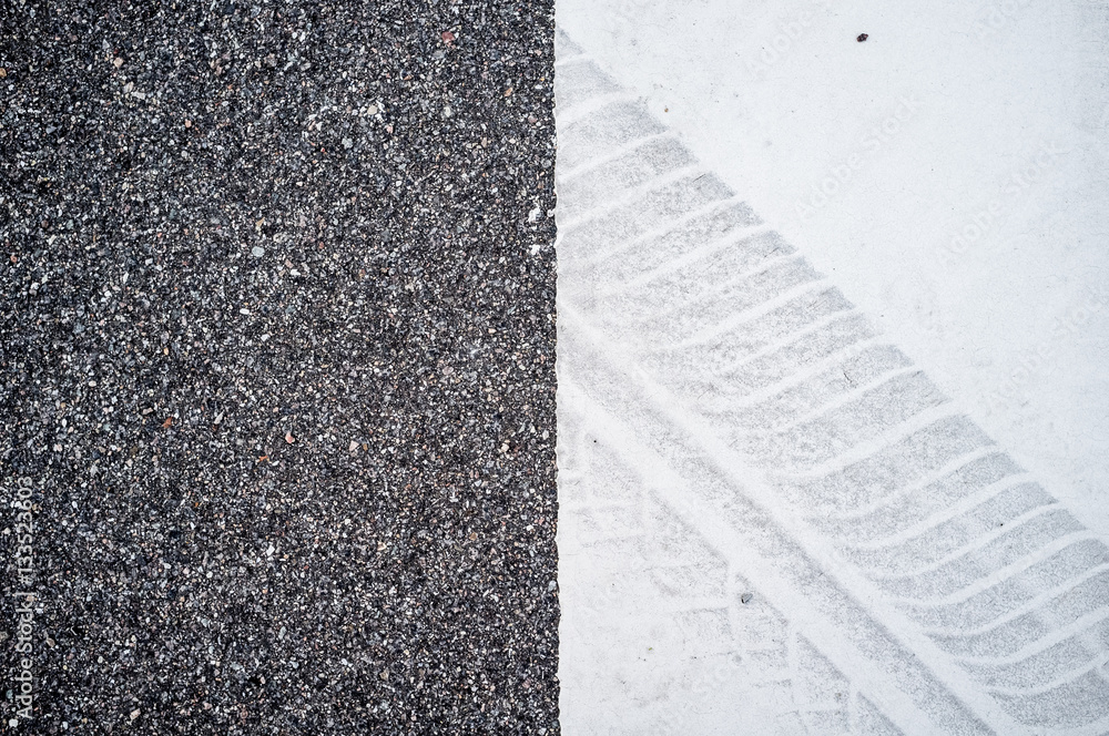 Tire track on a white surface on the road.