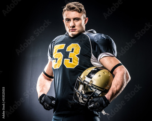 Фотография American football player holding helmet