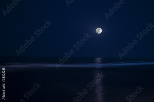Valokuvatapetti Full moon in night sky over moonlit water