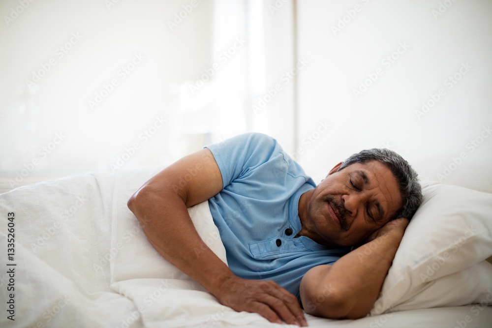 Senior man resting on bed in bedroom Senior man resting on bed in bedroom