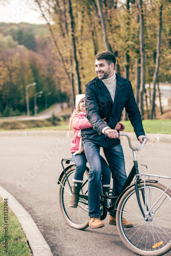 Father carrying daughter on bike