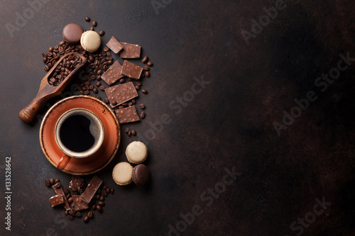 Coffee cup, chocolate and macaroons on old kitchen table