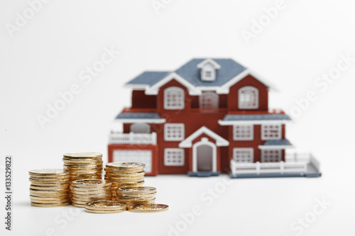 RMB coins stacked in front of the housing model (house prices, house buying, real estate, mortgage concept)