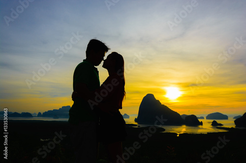 Couple lovers kiss on hill at sunrise