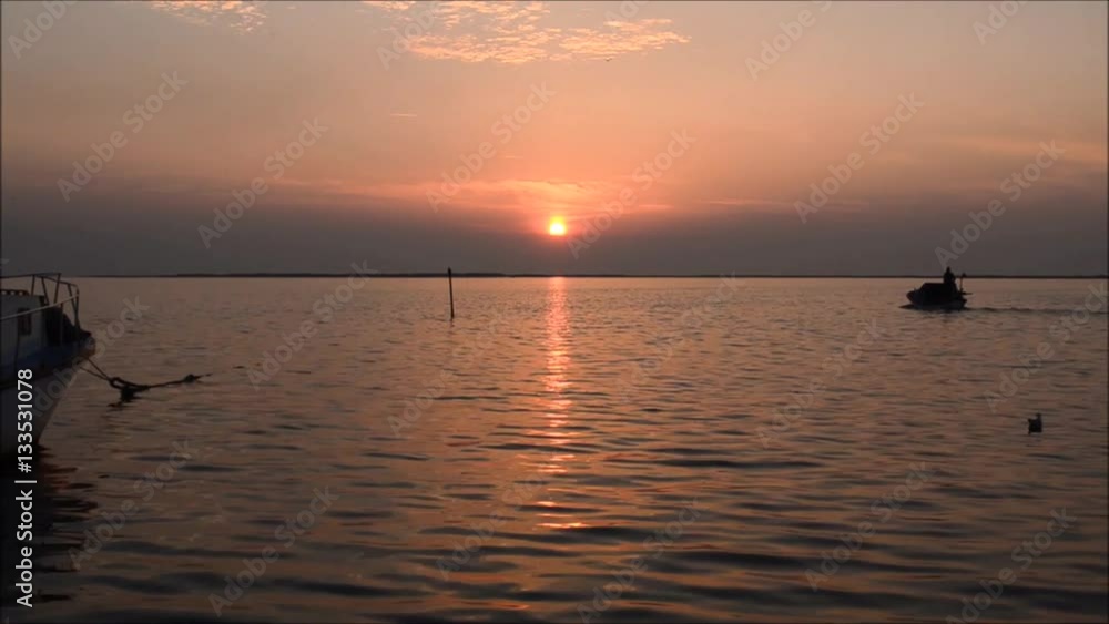 Fishing boat on sea at sunset in Izmir - Turkey. Seagulls swimming and flying on the sea, silhouette. Fishing boat on sea at sunset in Izmir - Turkey. Seagulls swimming and flying on the sea, silhouette.