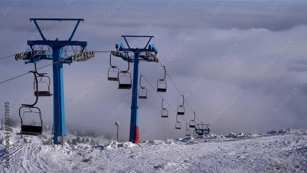 Ski chair-lift without skiers in snow-capped mountains. Ski chair-lift without skiers in snow-capped mountains.
