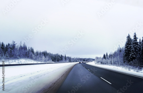 Traveling on a cloudy winter day. Highway curving. Snow on the ground. Image has a vintage effect. © Jne Valokuvaus