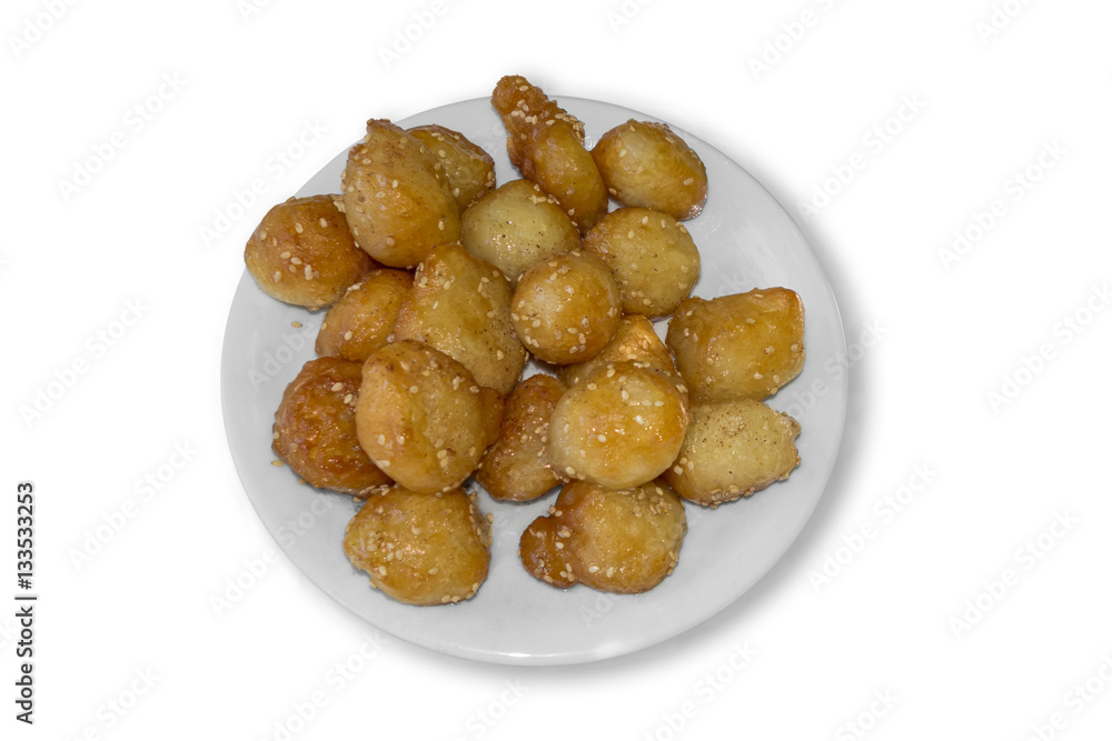 Greek donuts with sesame Loukoumades on the plate. Isolated on white background Greek donuts with sesame Loukoumades on the plate. Isolated on white background