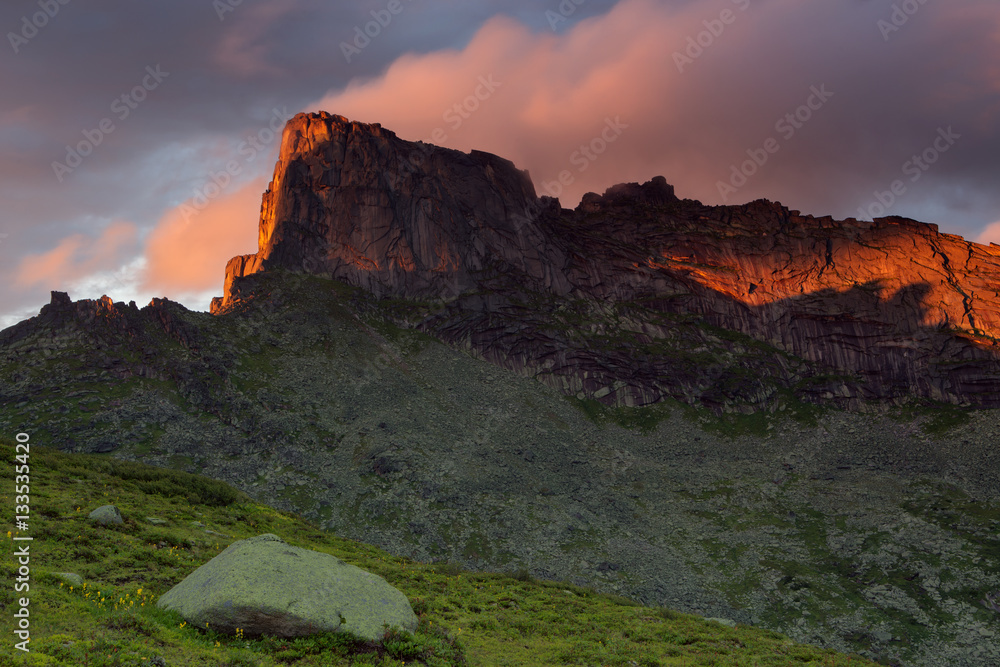 Rocky peak in the red light of the setting sun. Natural Park Ergaki. Western Sayan. Russia.