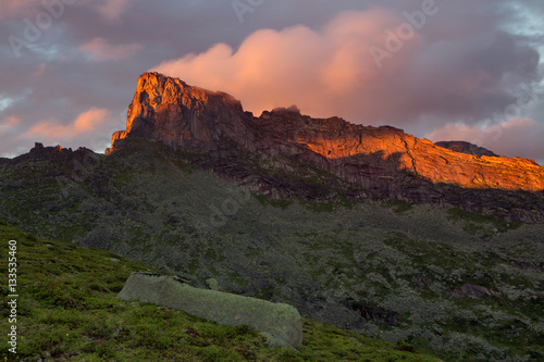 Rocky peak in the red light of the setting sun. Natural Park Ergaki. Western Sayan. Russia.