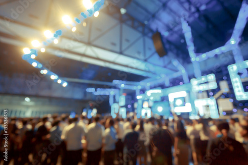 Crowd in front of concert stage with dancer blurred