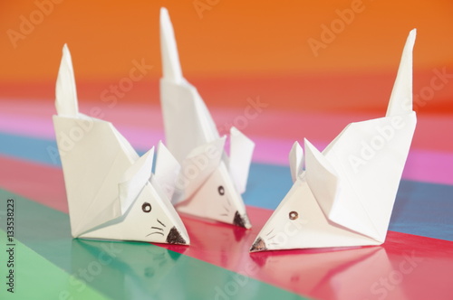Paper origami mouse isolated on the colorful background