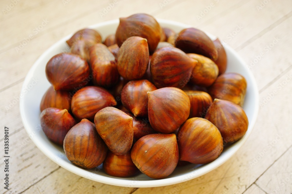 Bowl of fresh Italian chestnuts in the shell in winter Bowl of fresh Italian chestnuts in the shell in winter