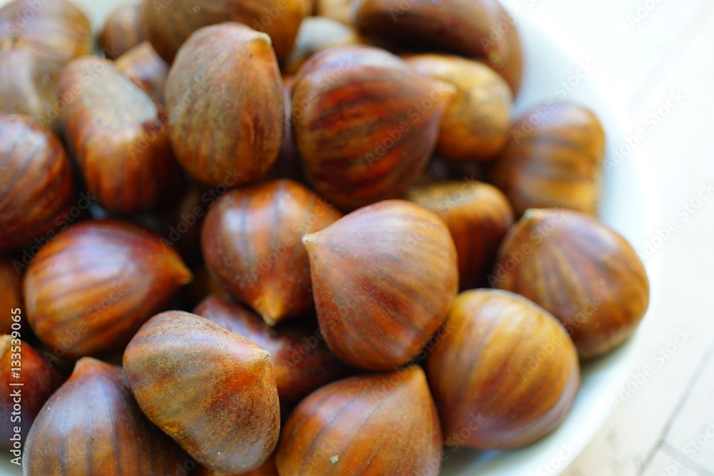 Bowl of fresh Italian chestnuts in the shell in winter Bowl of fresh Italian chestnuts in the shell in winter