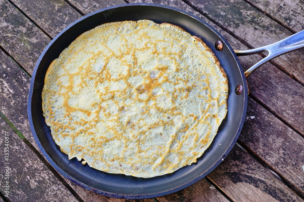 A French crepe just cooked in a flat pan