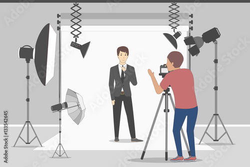 Male model in photo studio. White background with lights and cameras. Photographer making photos. Fashion clothes.