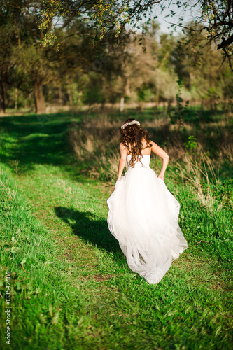 Beautiful bride in wedding dress and with a lovely mood in nature