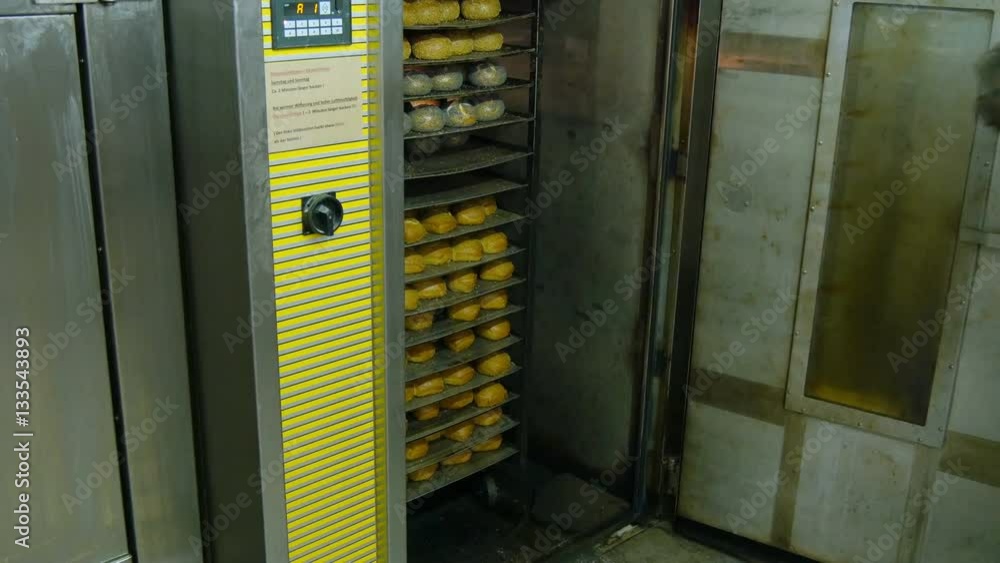 A german baker pull different roll buns from the rotary oven 4k 11684 A german baker pull different roll buns from the rotary oven 4k 11684